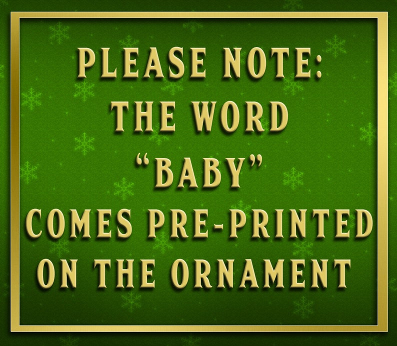 K&ouml;nnte beinhalten: Ein gr&uuml;nes Schild mit goldener Umrandung und einem Schneeflockenmuster. Das Schild lautet "PLEASE NOTE: THE WORD "BABY" COMES PRE-PRINTED ON THE ORNAMENT".