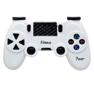 May include: White plastic video game controller ornament with black buttons and a black and white grid pattern on the top. The ornament has the words "Name" and "Year" written on it.