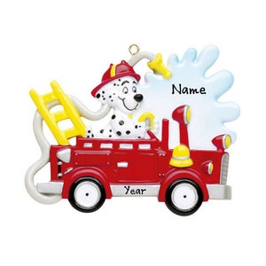 May include: A red fire truck ornament with a Dalmatian dog in the driver's seat. The ornament has a yellow ladder, a water splash design, and the words "Name" and "Year". The dog is wearing a red firefighter's hat.
