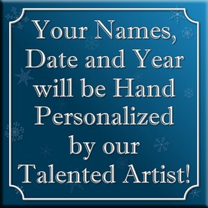 May include: A blue square sign with white snowflakes and white text that reads "Your Names, Date and Year will be Hand Personalized by our Talented Artist!"