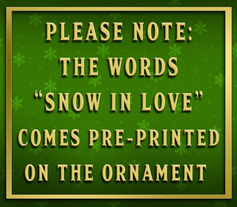May include: A green background with gold snowflakes and a gold border. The text "PLEASE NOTE: THE WORDS "SNOW IN LOVE" COMES PRE-PRINTED ON THE ORNAMENT" is written in gold letters.