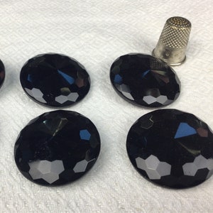 May include: Six black, faceted, round buttons with a raised center. The buttons are arranged in two rows of three.