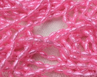 Perles allongées sur fil, rose foncé, effet givrée. Vintage Frosted, Elongated Pale Pink Beads in plastic.