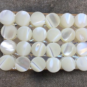 24 petits boutons anciens, en nacre, des années 40 sur carte, 1cm. 24 small vintage mother of pearl buttons. 40s. Made in occupied Japan. image 1