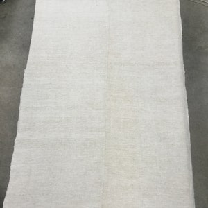 May include: A large, off-white linen tablecloth with two thin red stripes along the top and bottom edges.