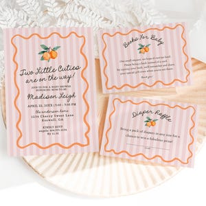 May include: A set of baby shower invitations and inserts with a peach and orange color scheme. The main invitation reads "Two Little Cuties are on the way!" with event details. Additional cards include "Books for Baby" and "Diaper Raffle."