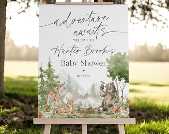 May include: A watercolor illustration of a woodland scene with a bear, deer, and a rabbit. The text reads "adventure awaits" and "Welcome to Hunter Brook's Baby Shower" with the date "03.22.2025".