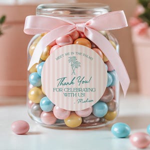 May include: A glass jar filled with colorful candy, tied with a pink ribbon and a thank you tag that reads "Meet me in the palms. Thank you! For celebrating with us! - Madison".