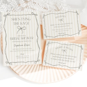 May include: Bridal shower invitation set with a bow design. The main invitation reads "She's Tying the Knot" and includes event details. Additional cards include registry and recipe request information. The cards are on a striped background.