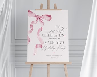 May include: A pink watercolour ribbon bow with the text "IT'S A sweet CELEBRATION. WELCOME TO MADELYN'S Birthday Party Saturday, August 10th 2022 Roswell, Ga"
