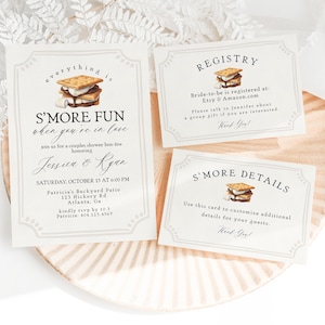 Könnte beinhalten: Ein Satz von drei Karten mit einem S'mores-Motiv. Die erste Karte ist eine Einladung zu einer Verlobungsfeier für Paare mit einem Lagerfeuer zu Ehren von Jessica & Kyan. Die zweite Karte ist eine Hochzeitsliste mit dem Text "Die Braut ist registriert bei: Etsy & Amazon.com". Die dritte Karte ist eine Detailkarte mit dem Text "Verwenden Sie diese Karte, um zusätzliche Details für Ihre Gäste anzupassen."