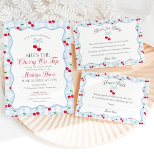 May include: Baby shower invitation set with a cherry theme. The invitation, book request, and diaper raffle cards feature a light blue gingham pattern, cherry illustrations, and the text "She's the Cherry On Top."