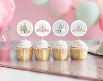 May include: Four cupcakes with white frosting, each topped with a round, scalloped-edge topper. The toppers feature Christmas-themed illustrations, including a Christmas tree, snow globe, and a ballerina. The background includes pink and green balloons.