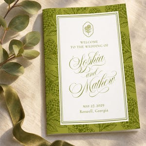 May include: A wedding program with a green floral design border and a white interior. The text reads "Welcome to the Wedding of Sophia and Mathew" with the date May 27, 2029, and location Roswell, Georgia.