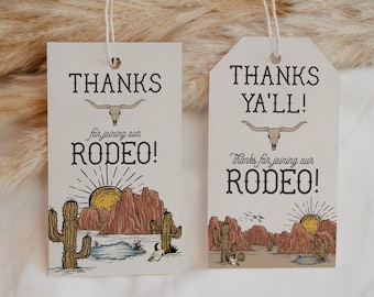 May include: Two beige rodeo-themed gift tags with string. One tag reads "THANKS for joining our RODEO!" and the other reads "THANKS YA'LL! Thanks for joining our RODEO!". Both tags feature a desert landscape with cacti, mountains, and a setting sun.