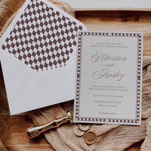 May include: A rehearsal dinner invitation with the names "Harrison and Ansley" in elegant script. The invitation is bordered with a brown dotted pattern and includes the date, time, and location. An envelope with a brown diamond pattern is visible.