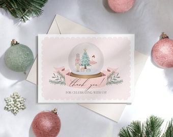 May include: A thank you card with a pink scalloped border features a snow globe illustration with a Christmas tree, nutcracker, and ballerina. The card reads "thank you!" and "for celebrating with us!" with festive decorations.
