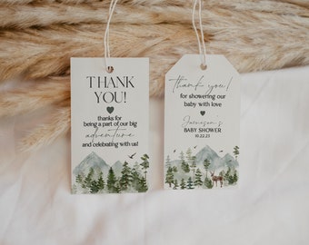 May include: Two thank you tags with a woodland theme. The tags are white with black text and a watercolor illustration of a forest with mountains. The text on the left tag reads "Thank You!" and "thanks for being a part of our big adventure and celebrating with us!" The text on the right tag reads "Thank you! for showering our baby with love Jameson's Baby Shower 10.22.23"