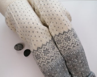 May include: White and gray knitted leg warmers with a geometric pattern. The leg warmers are made of a soft, fuzzy material.