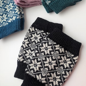 Puede incluir: Dos pares de polainas de punto con un patrón geométrico blanco y negro. Un par es negro y el otro es blanco.