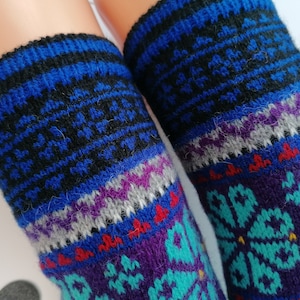 May include: A pair of colorful knitted socks with a geometric pattern in shades of blue, purple, teal, and red.