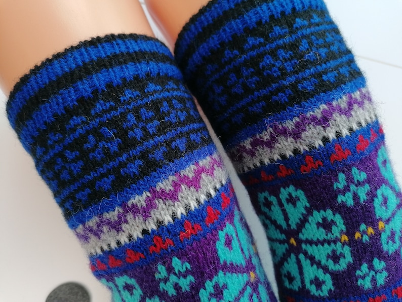 May include: A pair of colorful knitted socks with a geometric pattern in shades of blue, purple, teal, and red.