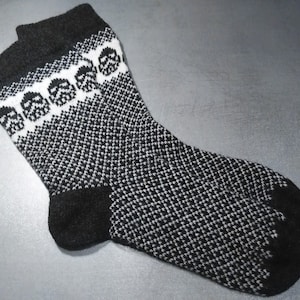 May include: Black and white patterned wool socks with a skull design on the cuff.