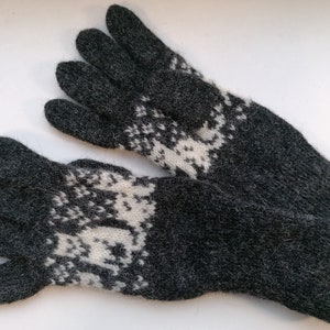 May include: A pair of gray knitted gloves with a white snowflake pattern.