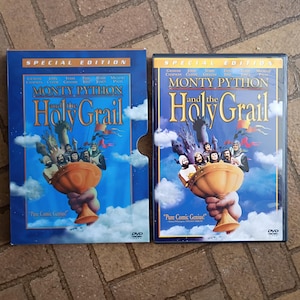 Könnte beinhalten: Zwei DVD-Hüllen von "Monty Python and the Holy Grail" werden gezeigt. Die Hüllen sind blau mit goldenem Schriftzug und einem Cartoon-Bild der Schauspieler. Der Text "Pure Comic Genius!" ist ebenfalls sichtbar.