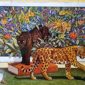 May include: A rectangular print featuring a dense jungle scene with three leopards, one black and two spotted, surrounded by colorful foliage and small monkeys. A large book and a small ceramic figurine are placed in the foreground.