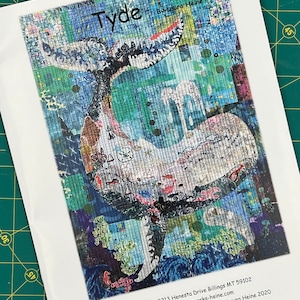 May include: A colorful abstract art piece titled "Tyde" by Laura Heine. The artwork features a blue and white whale tail with a variety of colors and patterns. The artwork is framed and ready to hang.