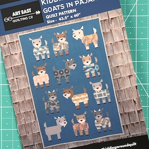 May include: A quilt pattern titled "Kidding Around Goats in Pajamas" by Art East Quilting Co. The pattern features a blue background with various goat designs wearing pajamas. The quilt size is 43.5" x 60".