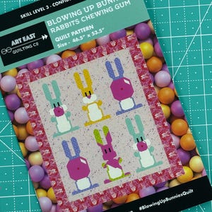 May include: A quilting pattern for a quilt featuring bunnies chewing gum. The pattern is called "Blowing Up Bunnies Rabbits Chewing Gum" and is 46.5 inches by 53.5 inches. The pattern is for a confident beginner quilter.