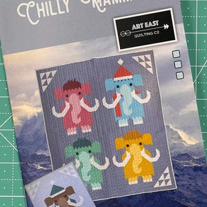 May include: A quilt pattern featuring four colorful mammoths wearing winter hats and scarves. The pattern is titled "Chilly Mammoth" and is from Art East Quilting Co.
