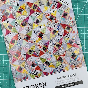 May include: A quilt pattern titled "Broken Glass" with acrylic templates included. The pattern features a colorful patchwork design of triangles and circles. The finished quilt measures 82 1/2 inches square. The pattern is by Jen Kingwell.