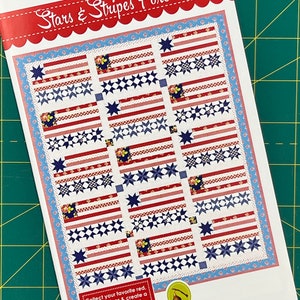 May include: A quilting pattern for a Stars & Stripes Forever quilt. The pattern features a design of red, white, and blue stars and stripes. The pattern is from Fig Tree & Co.