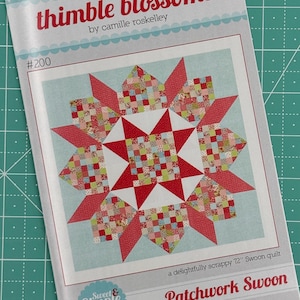 May include: A quilt pattern for a 72-inch quilt called "Patchwork Swoon" from the "Sweet & Simple" collection. The pattern features a starburst design with a red, white, and green color scheme. The pattern is called "thimble blossoms" and is designed by Camille Roskelley.