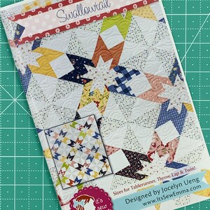 May include: A quilting pattern called "Swallowtail" with a colorful patchwork design. The pattern includes instructions for making a table runner, throw, lap quilt, and twin-sized quilt. It's designed by Jocelyn Ueng and available at www.ltsSewEmma.com.