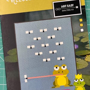 May include: A quilt pattern featuring a frog with a crown and a lily pad design. The pattern is titled "Welcome to My Pad" and is from Art East Quilting Co. The pattern is 42 inches by 53 inches.