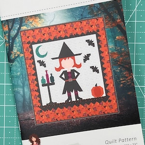 May include: A quilt pattern featuring a witch with a black hat and dress, a cauldron, and a pumpkin. The pattern is called "Little Witch" and is by Sew A Story. The finished size is 65 inches by 73 inches.