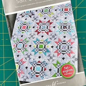 May include: A quilting pattern booklet titled "Salt & Pepper" with a colorful quilt design featuring a star pattern. The text "fat-eighth friendly!" is on a green circle. The booklet is by Amanda Murphy.