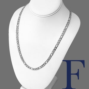 May include: A silver Figaro chain necklace on a white display stand. The chain is 6mm wide and made of stainless steel 316L.