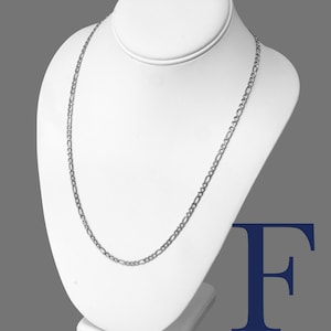 May include: A silver Figaro chain necklace with a 4mm width, made of stainless steel 316L. The chain is displayed on a white mannequin.