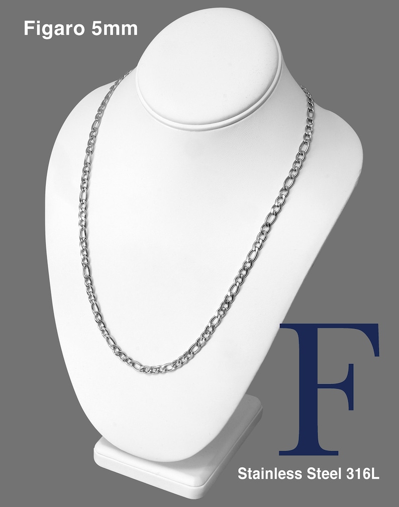 May include: A silver Figaro chain necklace with a 5mm width, made of stainless steel 316L. The chain is displayed on a white mannequin.