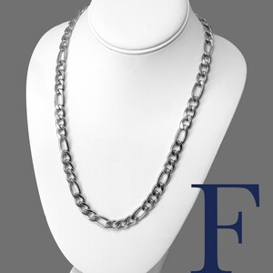 May include: A silver Figaro chain necklace with a 10mm width, made of stainless steel 316L. The chain is displayed on a white mannequin.