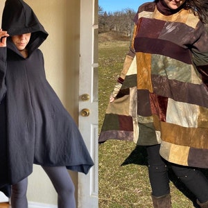 May include: Two women wearing long, loose-fitting hooded dresses. The dress on the left is black and the dress on the right is a patchwork of brown, green, and red fabrics.