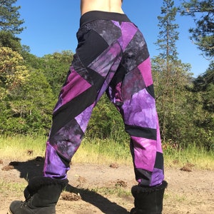 May include: Purple and black patchwork pants with a unique design. The pants are made of a soft, comfortable fabric and have a relaxed fit.