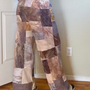 K&ouml;nnte beinhalten: Weite Patchwork-Hose in Braun-, Beige- und Graut&ouml;nen. Die Hose besteht aus verschiedenen strukturierten Stoffen, die ein einzigartiges, geometrisches Muster bilden. Der Bund ist einfarbig beige.