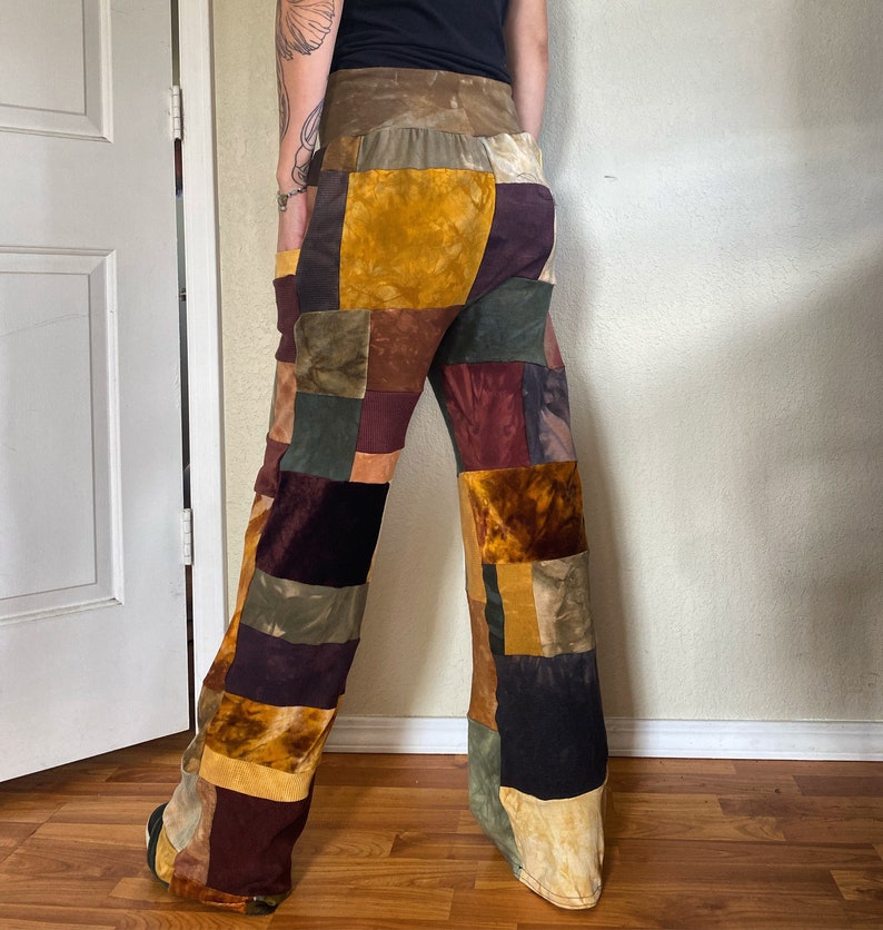 K&ouml;nnte beinhalten: Patchworkhose in verschiedenen Farben, darunter Gold, Braun, Burgunderrot und Olivgr&uuml;n. Die Hose hat ein weites Bein und besteht aus unterschiedlich strukturierten Stoffen. Der Bund ist einfarbig braun.