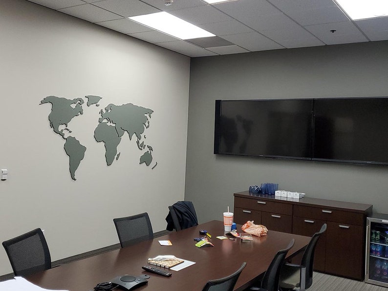 Puede incluir: Una sala de conferencias con un gran mapa del mundo gris en la pared, una larga mesa de madera marr&oacute;n con sillas, dos televisores de pantalla plana grandes, un armario con cajones y un peque&ntilde;o refrigerador.